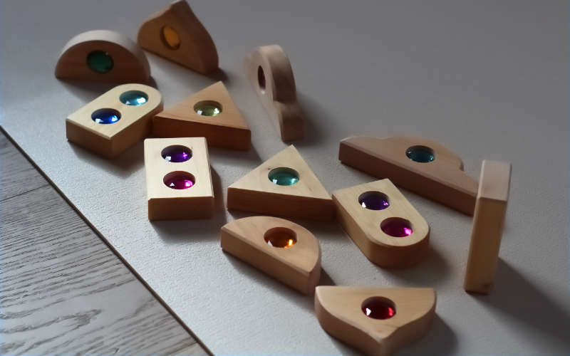 Bauspiel Funkeldächer | Holzbausteine in verschiedenen Dachformen mit eingelegten, bunten Acrylsteinen